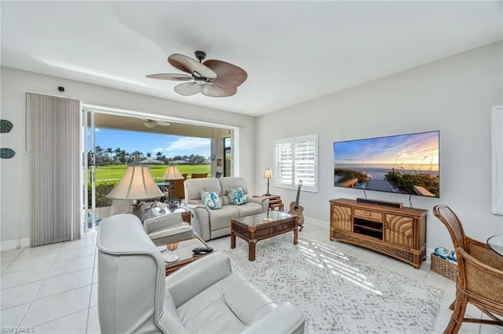 Living room featuring a ceiling fan and light tile patterned floors