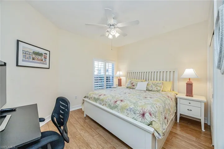 Bedroom with light wood-type flooring, a desk, and a ceiling fan
