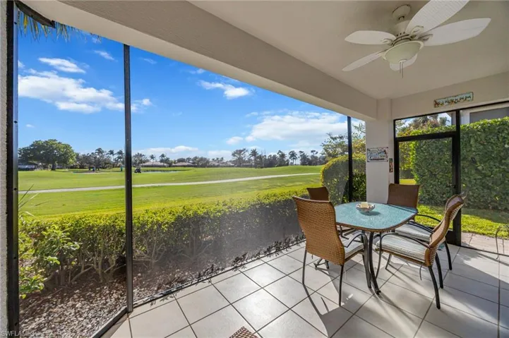 Sunroom with view of golf course, ceiling fan, and outdoor dining area