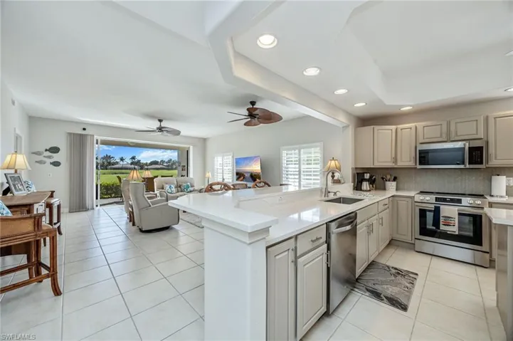 Kitchen featuring stainless steel appliances, open floor plan, a peninsula, recessed lighting, and light tile patterned floors