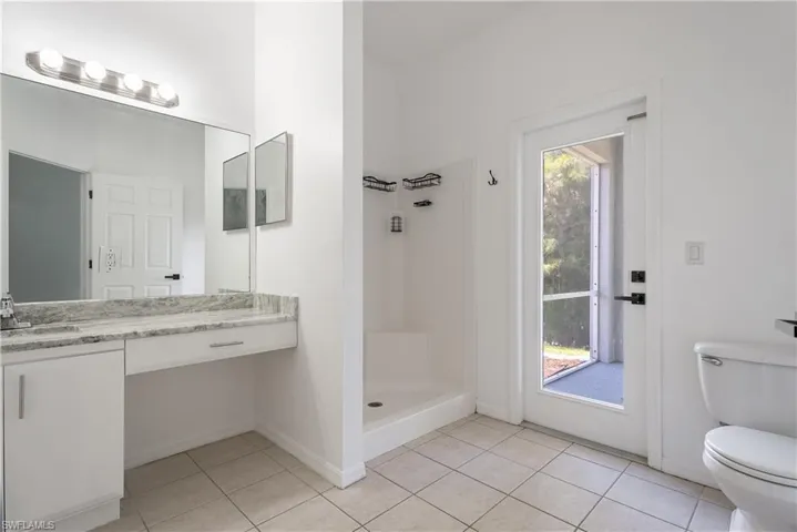 Bathroom vanity featuring a light-toned stone countertop and integrated sink, possible pool bath in future!