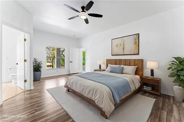 STAGED Spacious room featuring wood-finish flooring, a contemporary ceiling fan, and a large window
