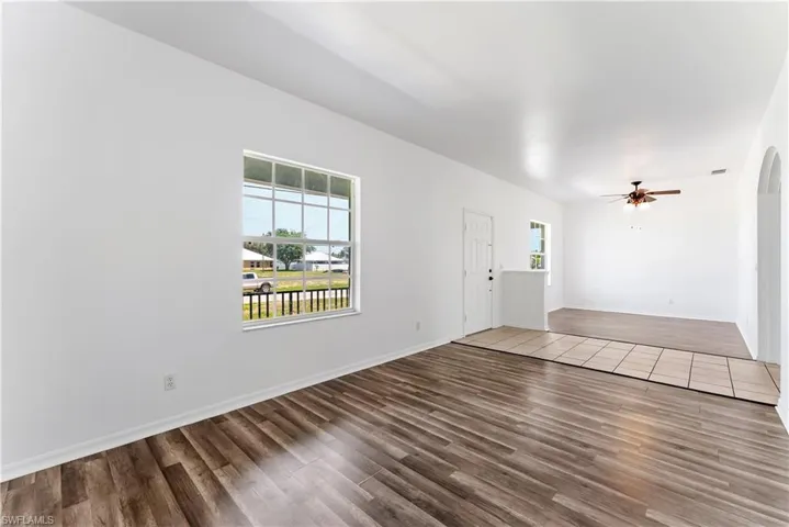 Open concept interior featuring wood-finish flooring, white walls, and a multi-pane window