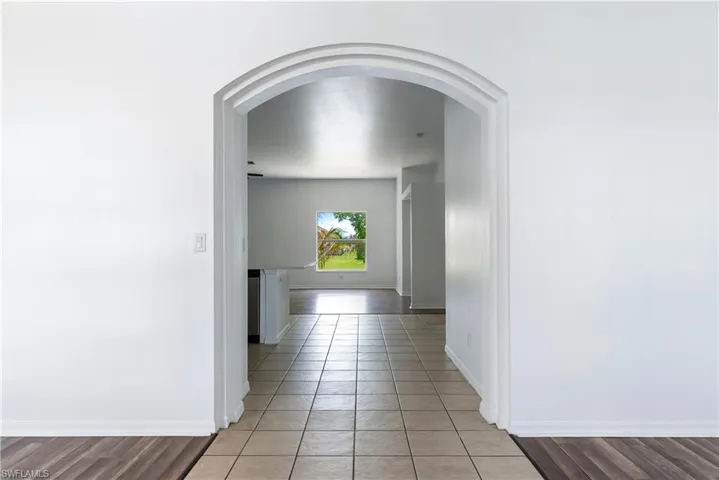 Archway entry to interior space featuring tile flooring