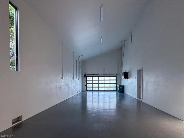 Large Garage featuring high vaulted ceiling and plenty of natural light