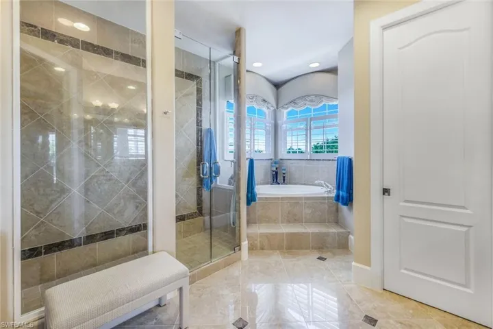 Bathroom featuring tile flooring and shower with separate bathtub
