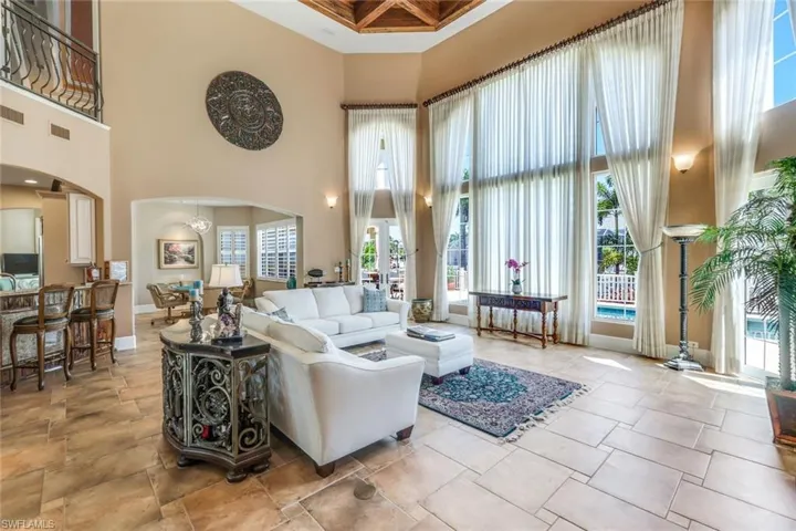 Living room with a high ceiling and light tile floors