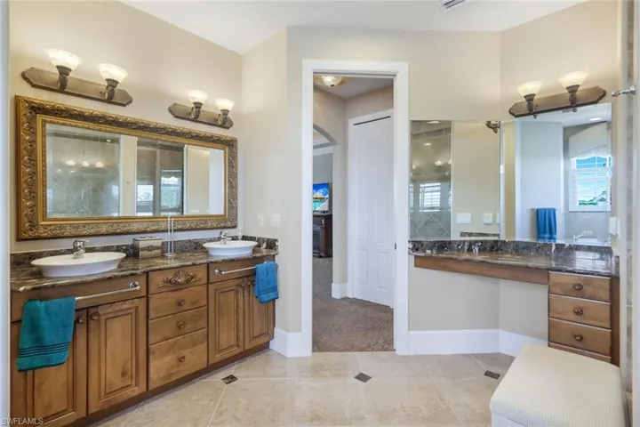 Bathroom featuring dual bowl vanity and tile flooring