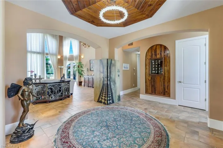 Foyer entrance featuring a tray ceiling, wood ceiling, and light tile floors