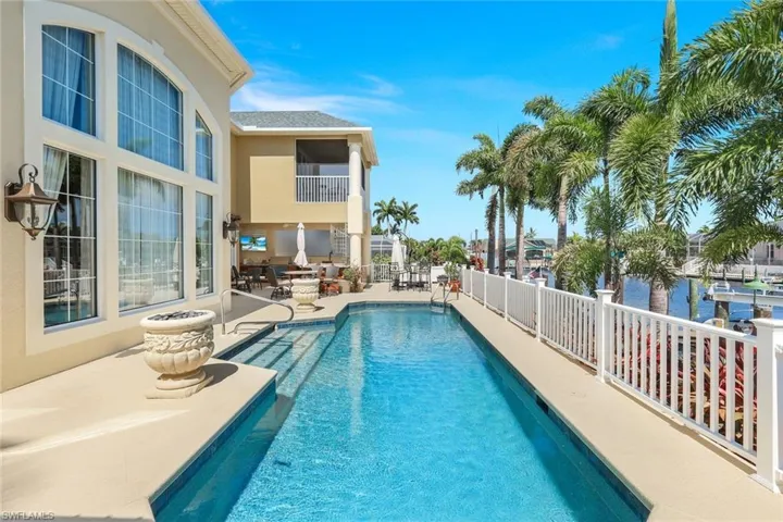 View of swimming pool with a patio and a water view