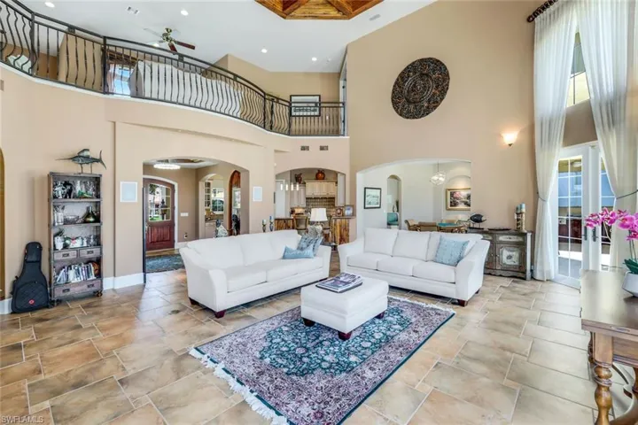 Tiled living room featuring a high ceiling and ceiling fan
