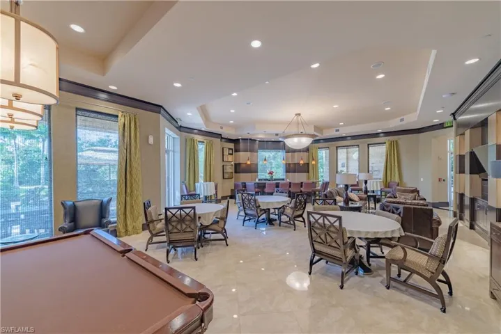 Dining space with billiards, a tray ceiling, and light tile floors