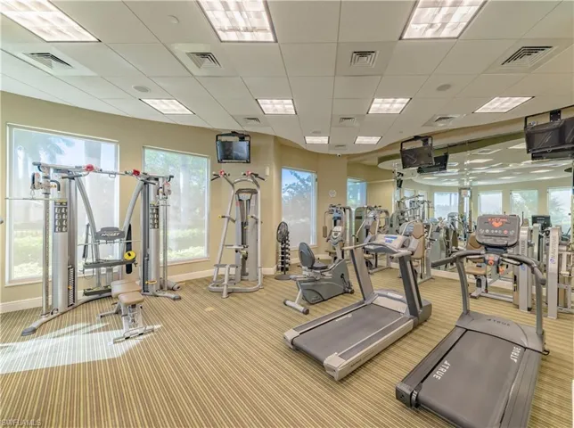 Workout area featuring light carpet and a paneled ceiling