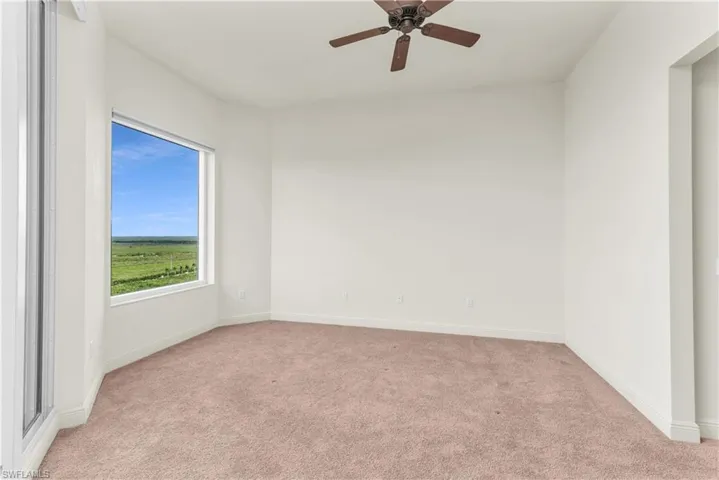 Unfurnished room featuring ceiling fan and light colored carpet