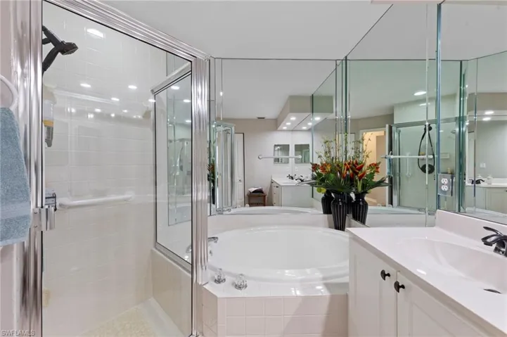Bathroom with a shower stall, two vanities, and a bath