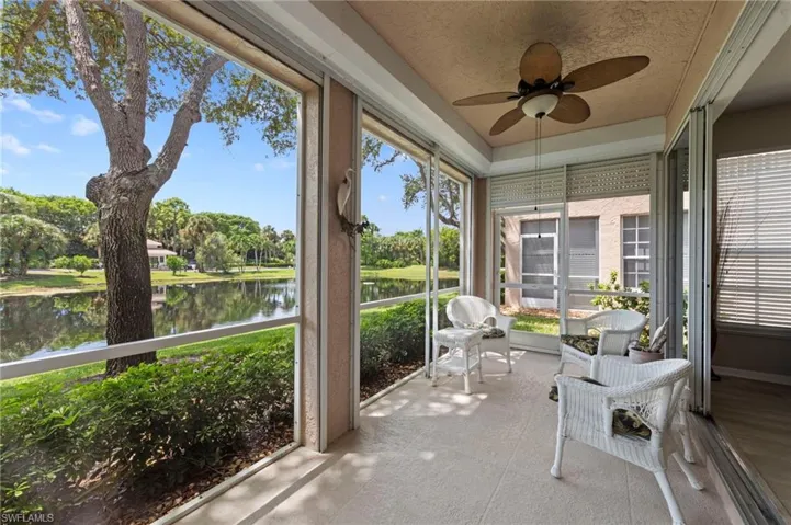 Sunroom / solarium featuring ceiling fan and a water view