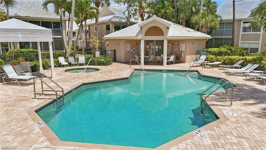 Community pool featuring a hot tub and a patio area
