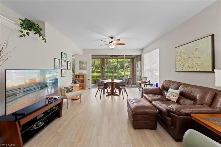 Living room with ceiling fan and light wood-style floors