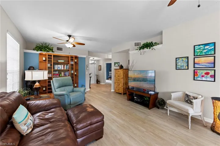Living room with ceiling fan and light wood-style floors