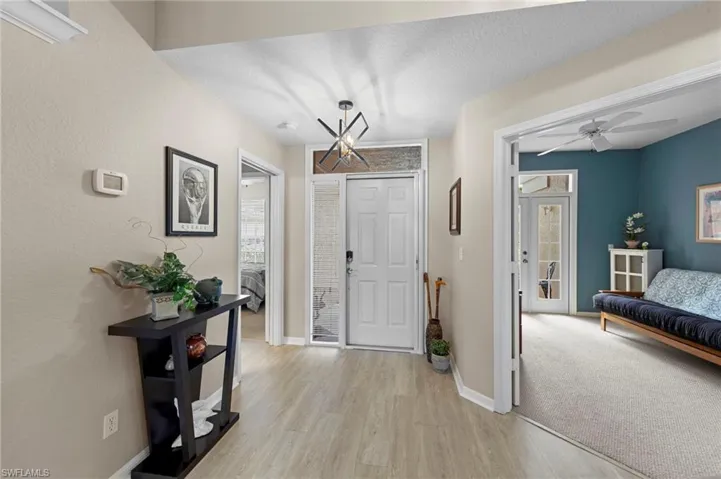 Entryway featuring light wood-style floors, a ceiling fan, plenty of natural light, and a textured ceiling