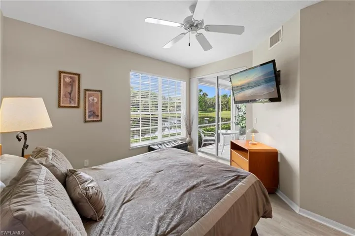Bedroom featuring access to outside, wood finished floors, and a ceiling fan