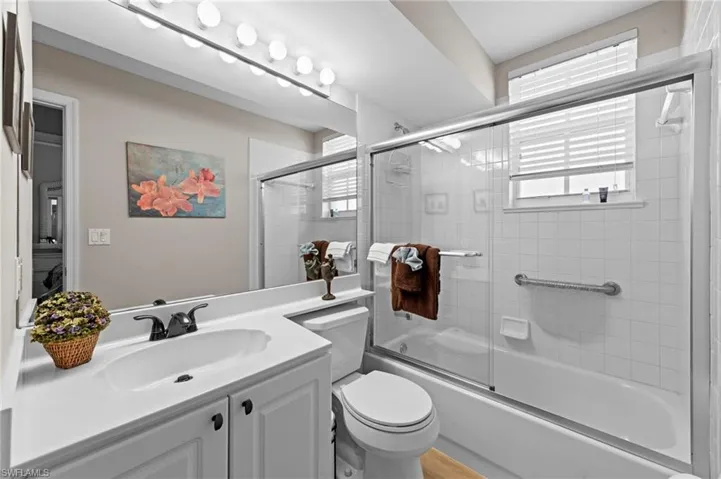 Bathroom featuring enclosed tub / shower combo and vanity