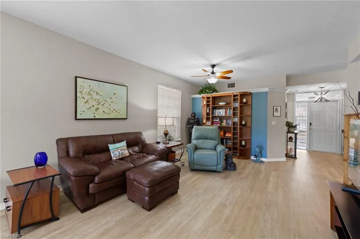 Living room featuring a ceiling fan, light wood finished floors, and healthy amount of natural light