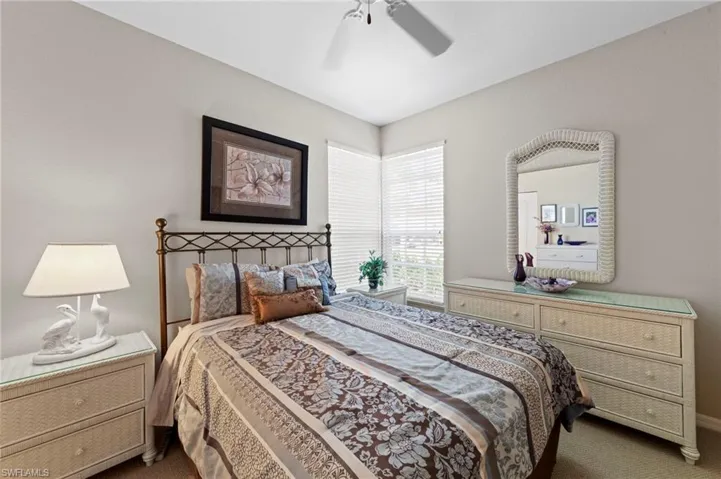 Bedroom with dark carpet and a ceiling fan