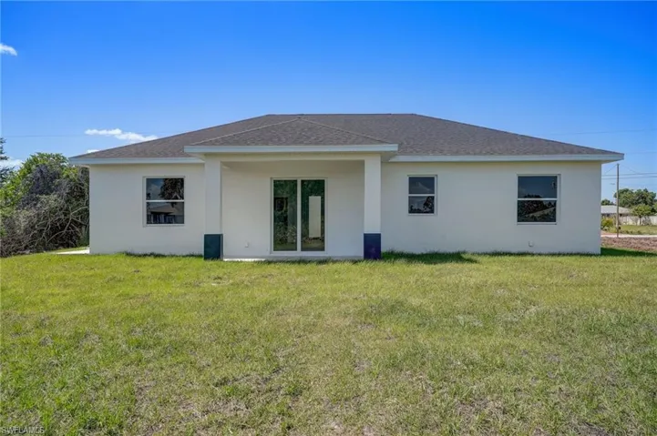 Rear view of house with a lawn