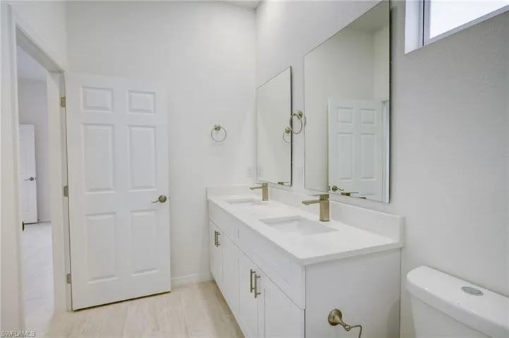Bathroom with double vanity and toilet