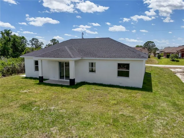 Rear view of property with a yard