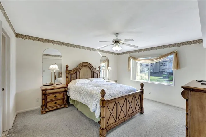 Carpeted bedroom with ceiling fan and baseboards