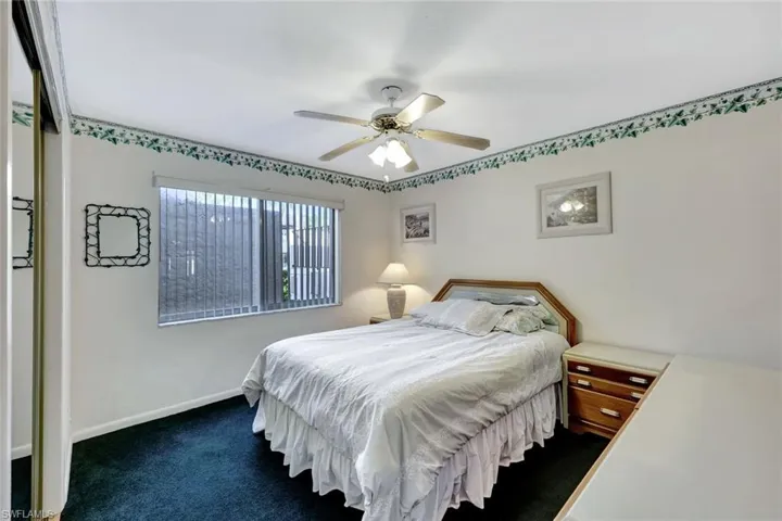 Bedroom with a ceiling fan and dark carpet