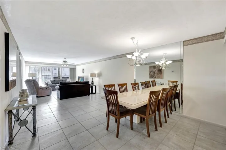 Dining area with ceiling fan, a chandelier, and light tile patterned flooring
