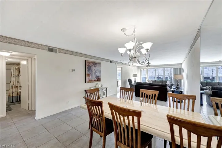 Dining area featuring light tile patterned flooring and a chandelier