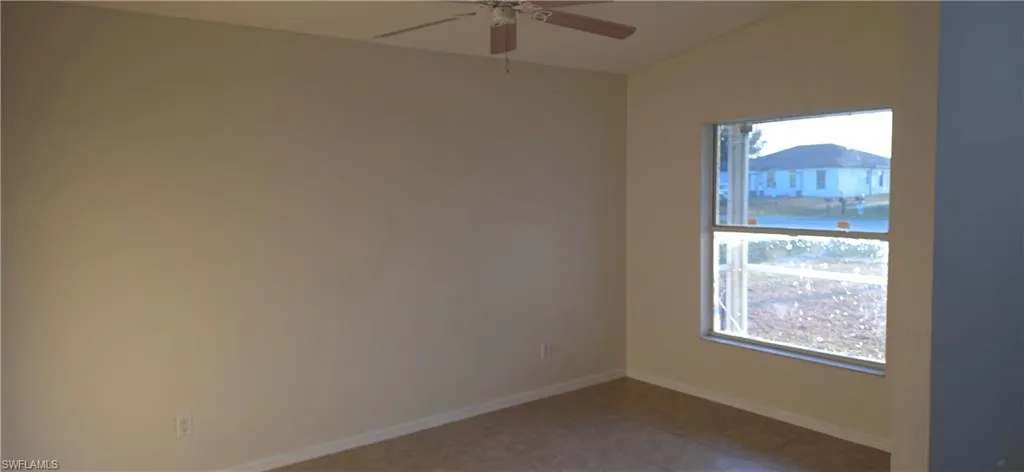 Spare room featuring ceiling fan and vaulted ceiling