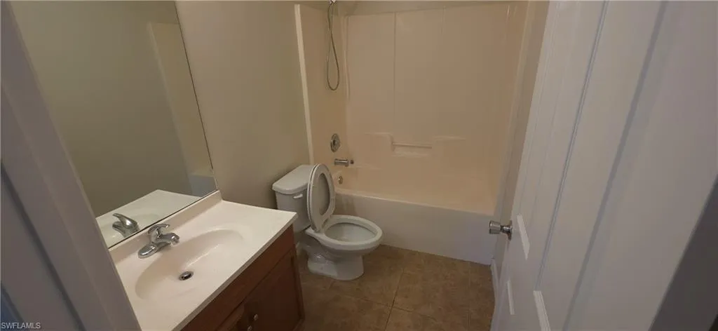 Full bath featuring vanity, tub / shower combination, and light tile patterned floors