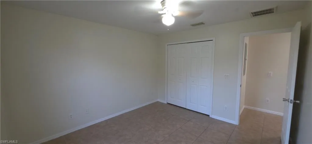 Unfurnished bedroom with a closet and a ceiling fan