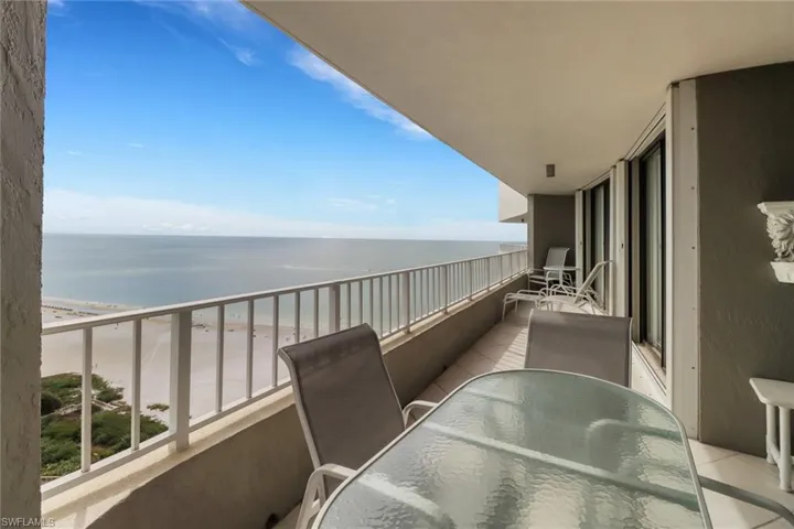Balcony featuring a view of the beach and a water view