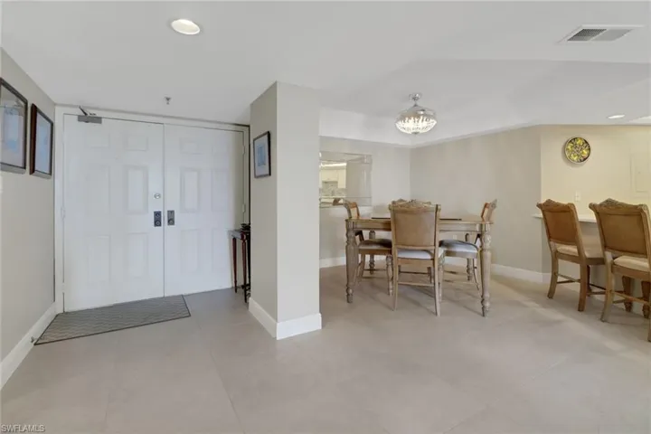 Kitchen with a raised ceiling, sink, white appliances, and a breakfast bar area