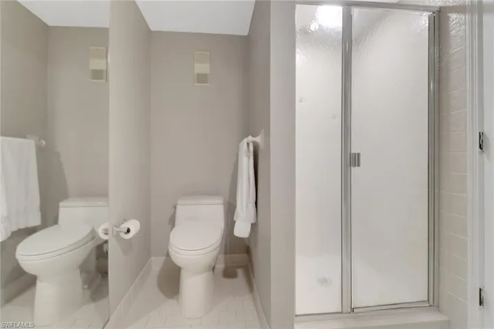 Bathroom with tile flooring, toilet, sink, and tiled tub