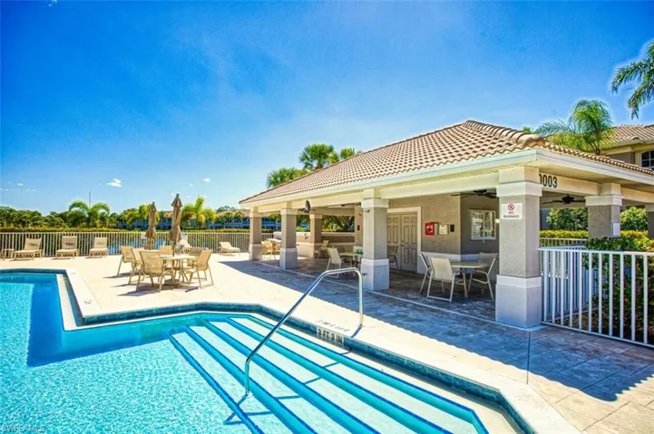 Community pool featuring outdoor dining space, ceiling fan, and a patio