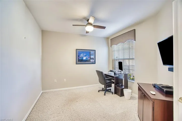 Home office featuring ceiling fan, baseboards, and carpet flooring