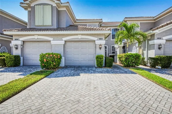 View of front of home with decorative driveway, stucco siding, and a tile roof