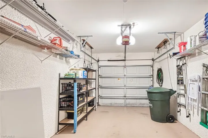 Garage featuring a garage door opener and a textured wall
