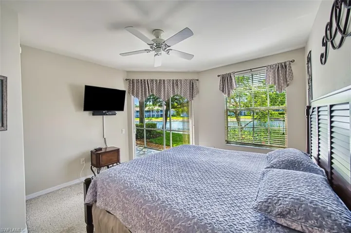 Bedroom with access to exterior, baseboards, carpet floors, and a ceiling fan