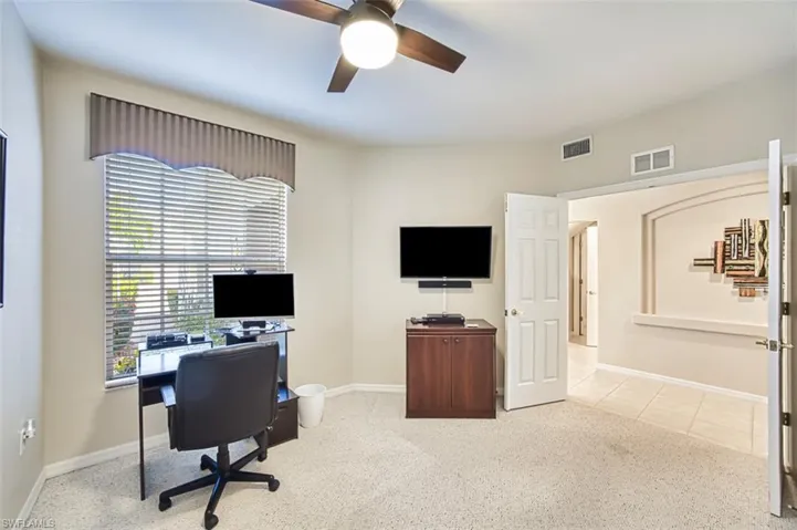 Home office with ceiling fan and baseboards