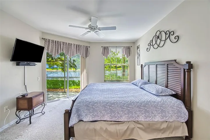 Carpeted bedroom featuring access to exterior, a ceiling fan, and baseboards