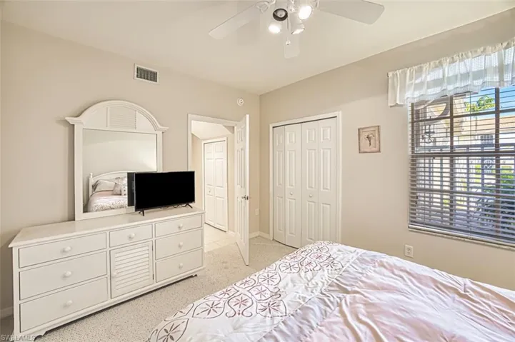 Bedroom featuring light carpet, a ceiling fan, a closet, and baseboards