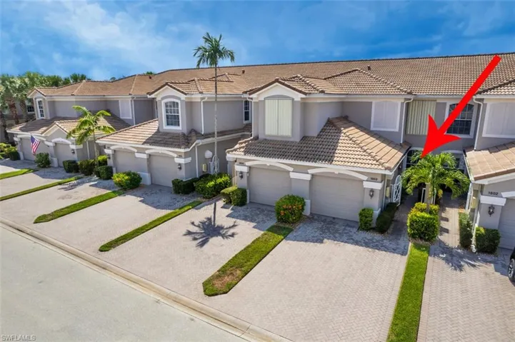 View of front facade featuring a tile roof, driveway, stucco siding, and a garage